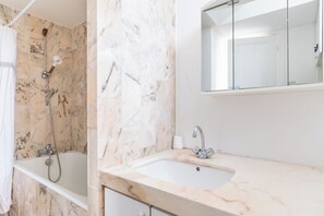 A bathroom with a bathtub, a shower, a sink, and a mirror. - Cozy 1BDR Apartment for 4 Near Champs-Elysees (Paris)