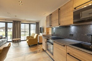Eine moderne Küche mit Holdekor, einem eingebauten Ofen und einem großen Fenster.