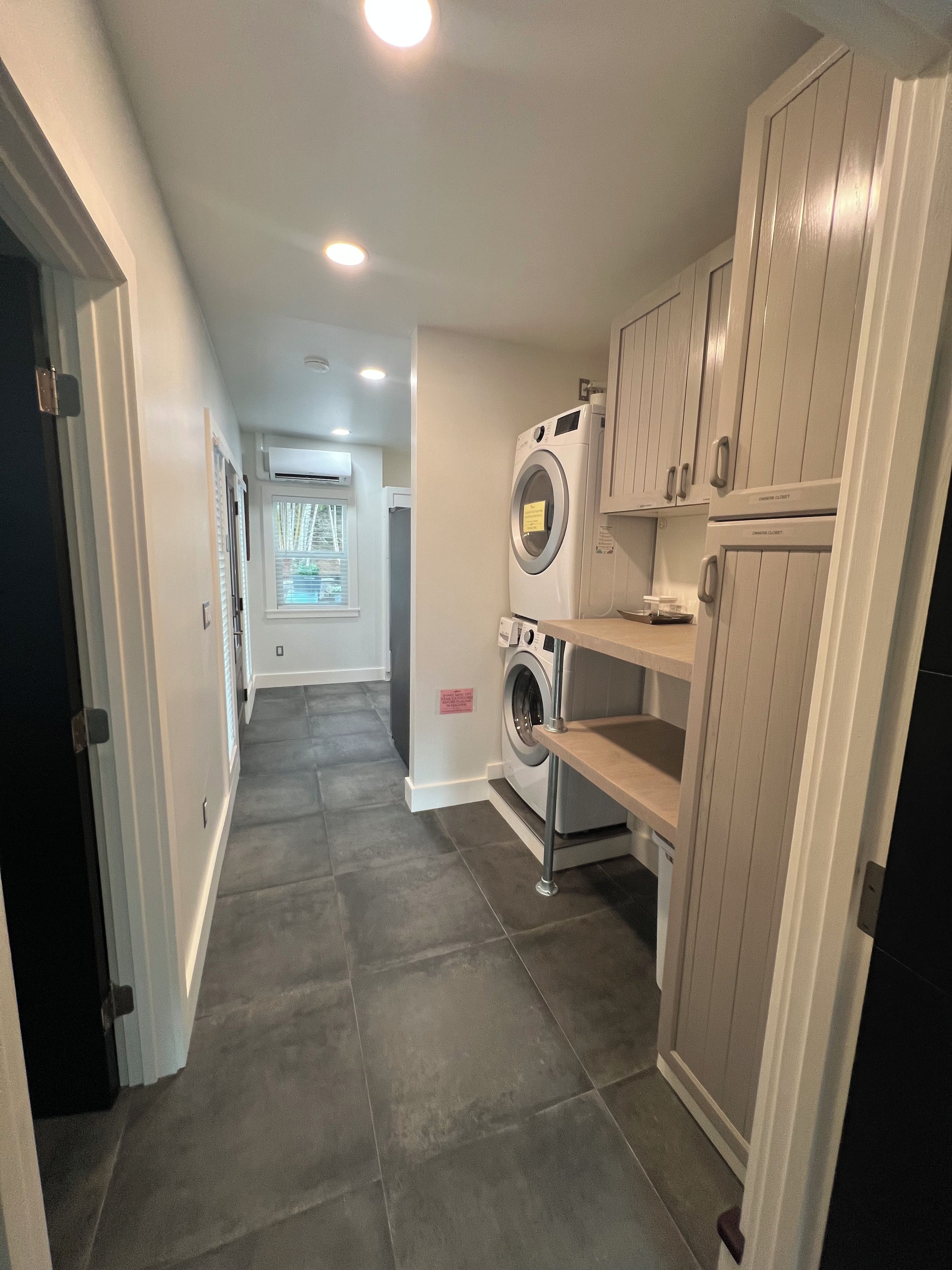 A laundry area with a washing machine, dryer, and storage cabinets.