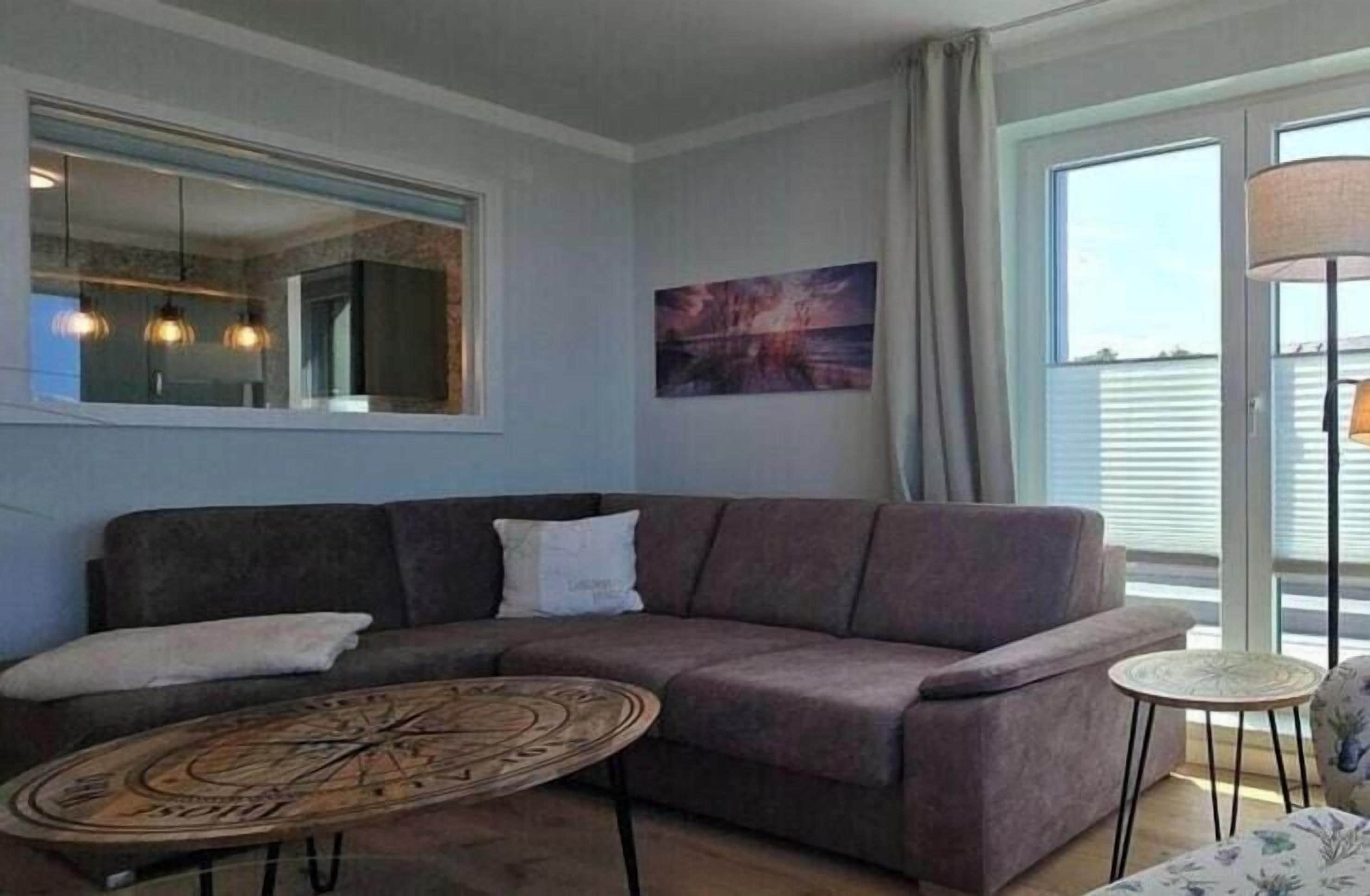 A living room with a sofa, a round coffee table, and a small side table.