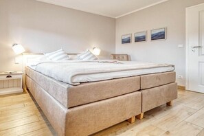 Ein Schlafzimmer mit einem Bett, Nachttischen und Wandlampen.