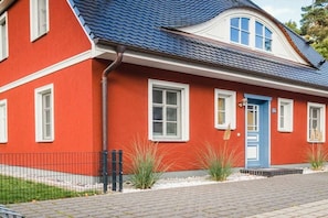 A red house with a blue door, white windows, and a blue roof. - Holiday home with 3 bedrooms (Ostseebad Prerow)