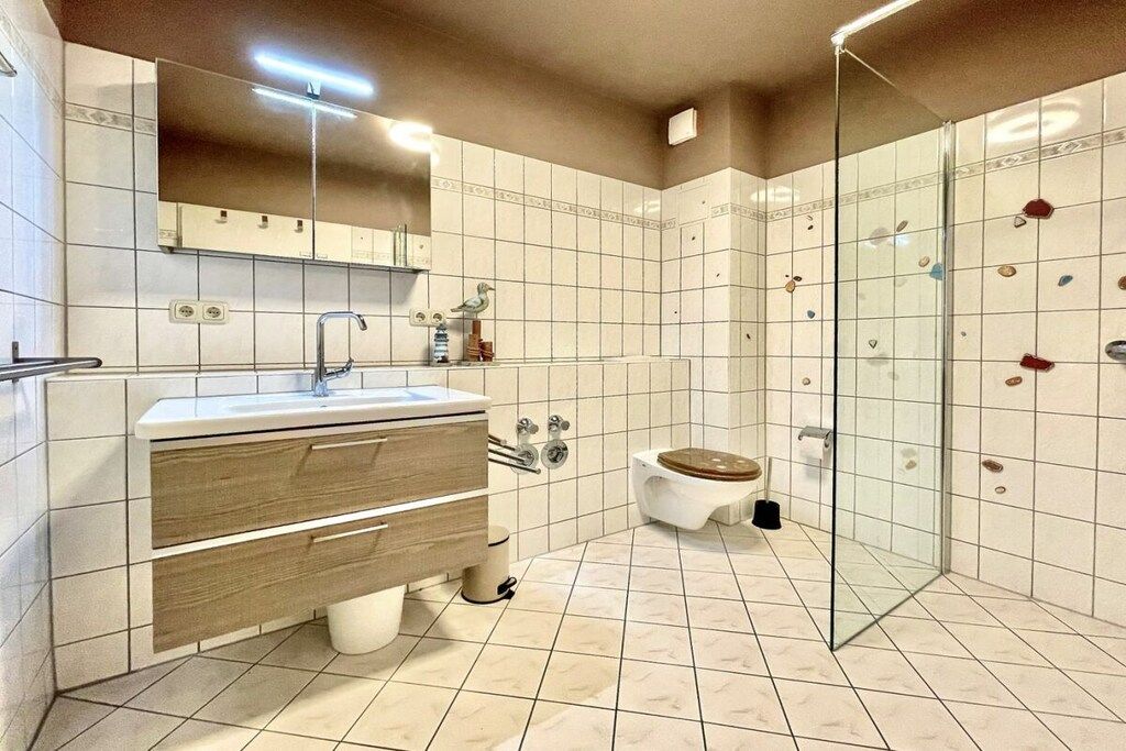 Ein modernes Badezimmer mit Waschtisch, Toilette und Duschkabine.