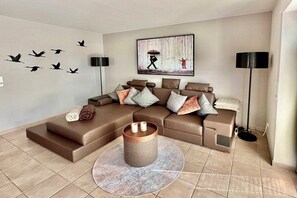 A modern living room with a sectional sofa, a coffee table, and wall art. - Holiday apartment with 2 bedrooms (Zingst)