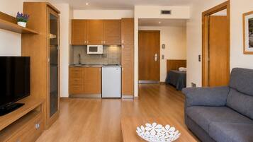 Un appartement moderne comprenant un salon, une cuisine et une chambre.
