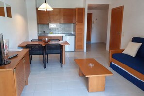 Een compacte woonruimte met een kitchenette, een eethoek en een zithoek.