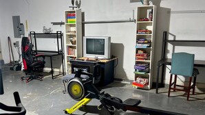 Une pièce équipée d’un vélo d’appartement, d’une télévision et d’une bibliothèque.