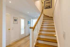 Una escalera de madera con barandillas blancas que conduce a un piso superior.