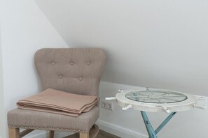 A chair with a folded blanket and a table with a glass top and wheels. - Villa Jansen 8 - OG/DG (Wenningstedt)