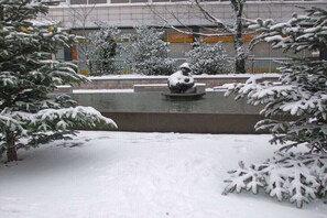 A snow-covered outdoor area with a water feature and snow-laden trees. - Villa Jansen 8 - OG/DG (Wenningstedt)