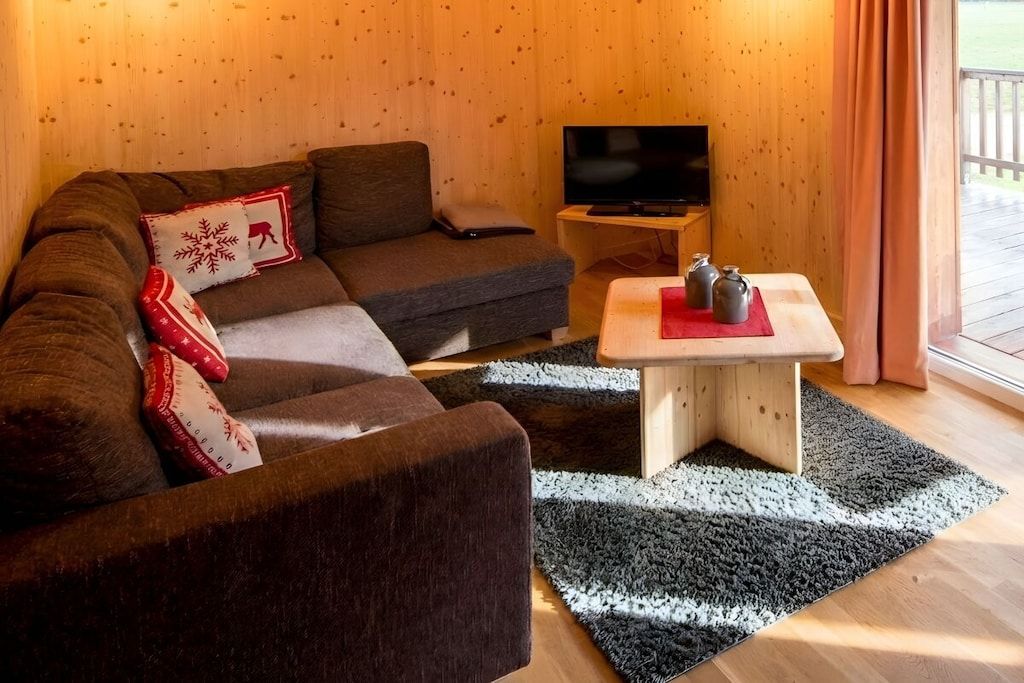 A cozy room with a sofa, a television, and a small table with decorative items.