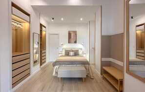 A modern bedroom with a large bed, bedside tables, a bench, and a wardrobe. - Jose Lasso de la Vega Romero (Málaga)
