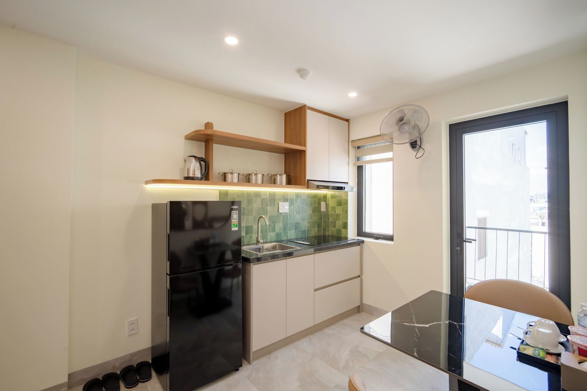 Una cocina moderna con refrigerador integrado, un lavamanos y un ventanal.
