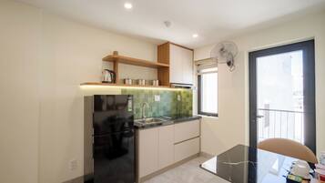Una cocina moderna con refrigerador integrado, un lavamanos y un ventanal.