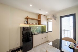 A modern kitchen with a built-in refrigerator, a sink, and a window. - Weal Hotel & Apartment (Da Nang)