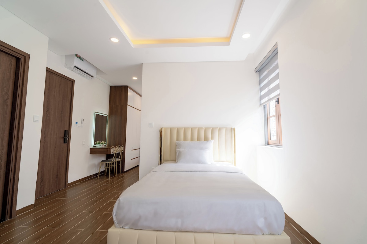 Una habitación de hotel con una cama, un escritorio y una silla.