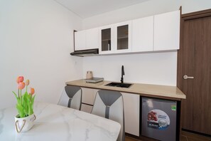 A compact kitchen with a sink, a coffee machine, and a refrigerator. - Sunset Bridge Hotel Phu Quoc (Phu Quoc)