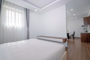 A hotel room with a bed, a desk, and a kitchenette. - Sunset Bridge Hotel Phu Quoc (Phu Quoc)
