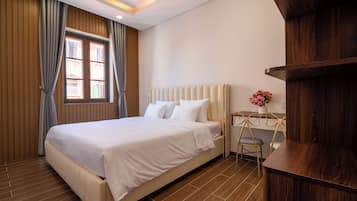 A modern bedroom with a large bed, wooden panel walls, a window with curtains, a bedside table with a vase, and a wooden cabinet.