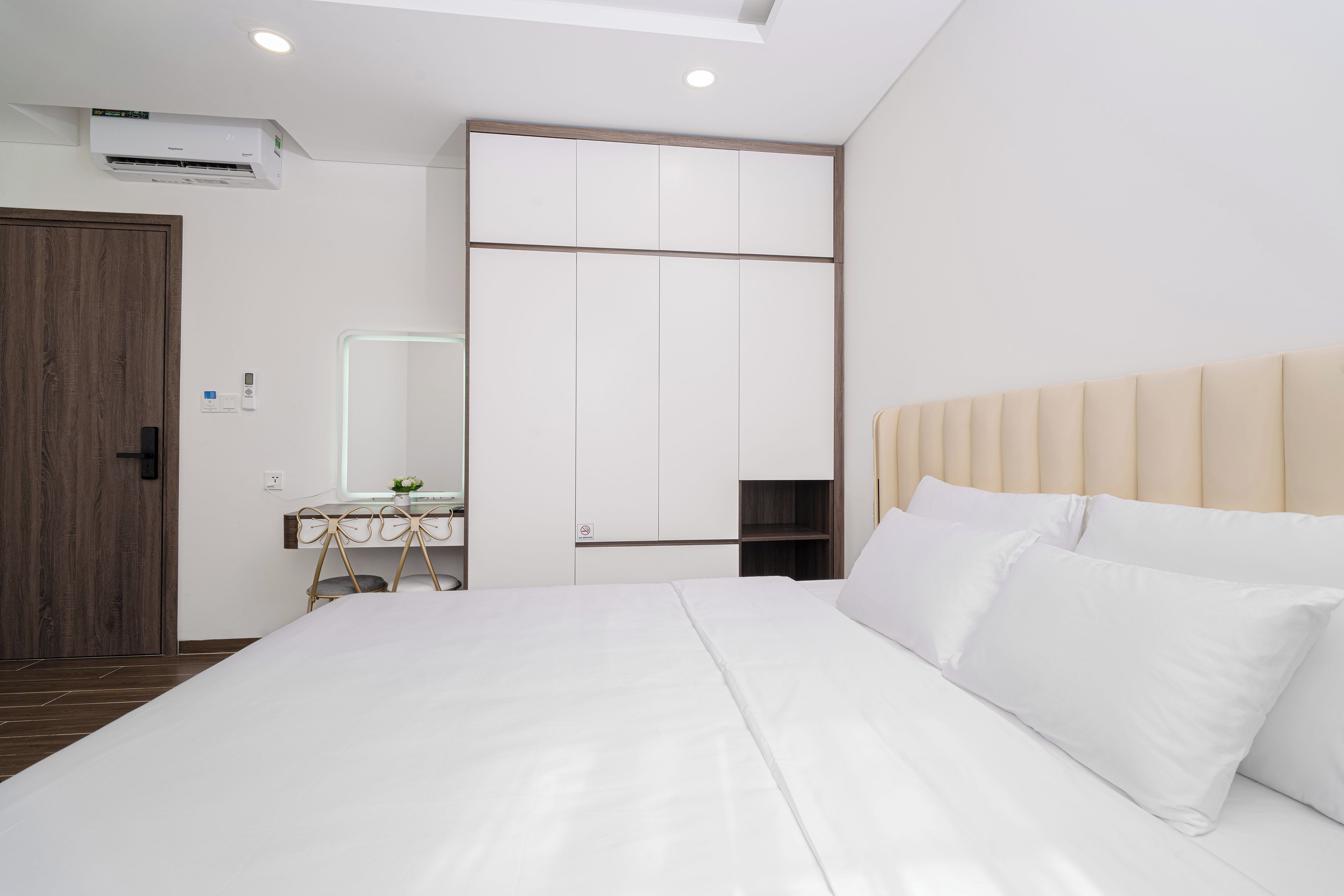 Quarto moderno com cama, mesa de cabeceira e guarda-roupa.