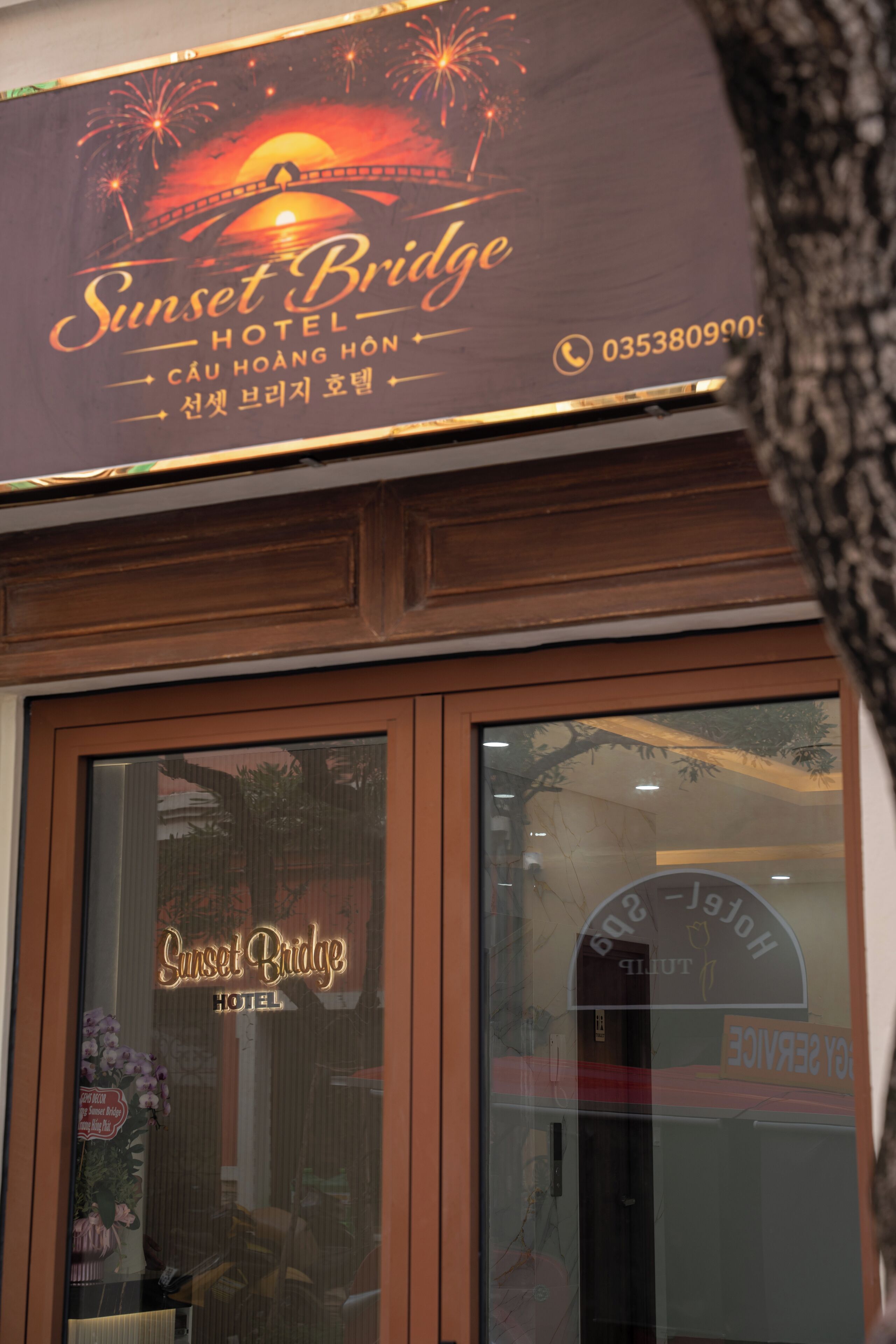 Segnaletica di un hotel con il nome 'Sunset Bridge Hotel' e un numero di telefono.
