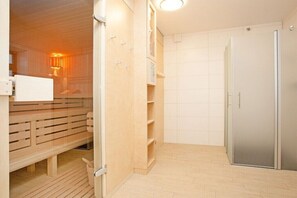 Une salle de bain moderne équipée d’une douche, de toilettes et d’un banc intégré.