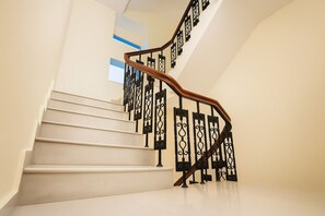 Una escalera con barandilla de madera y balaustradas de metal negro.
