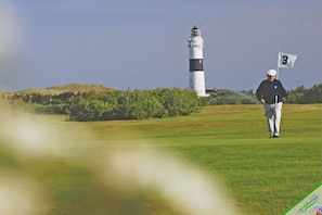A golf course with a lighthouse in the background. - Westwind Country House (Keitum)