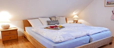 Un dormitorio con cama, mesitas de noche y una bandeja con alimentos para el desayuno.