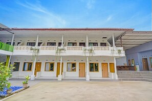 A two-story building with a covered entrance and multiple doors. - Luxury Deluxe DBL Retreat W/ Free Wifi and Parking (Surakarta)