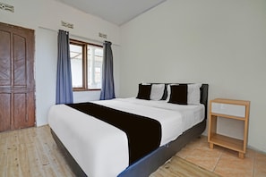 A bedroom with a bed, curtains, a wooden nightstand, and a window. - Luxury Deluxe DBL Retreat W/ Free Wifi and Parking (Surakarta)