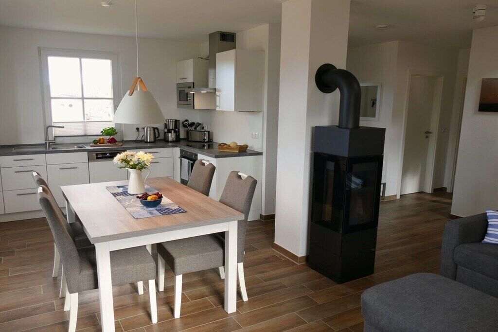 A modern kitchen with a dining area, a built-in oven, and a fireplace.