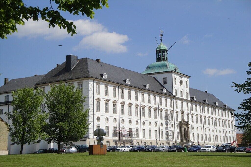 A large, historic building with a prominent tower and a central entrance.