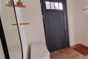A room with a dark door, a white bench, and a small window above the door. - Holiday home in Zierow with swimming pool (Zierow)