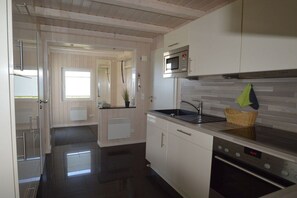 Een moderne keuken met witte kastjes, een magnetron, een spoelbak en een vaatwasser.