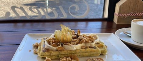 A plate of food with a dessert on a table.