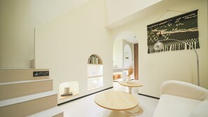 A modern interior with a staircase, a round table, and a sofa.