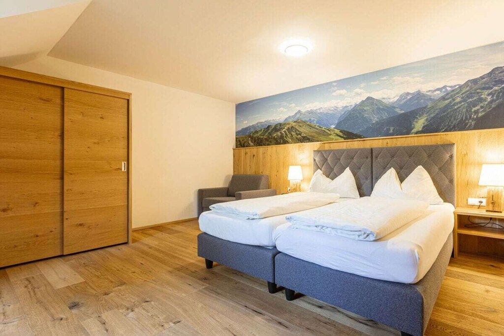 Une chambre d’hôtel avec un lit, une chaise, un bureau et une armoire.