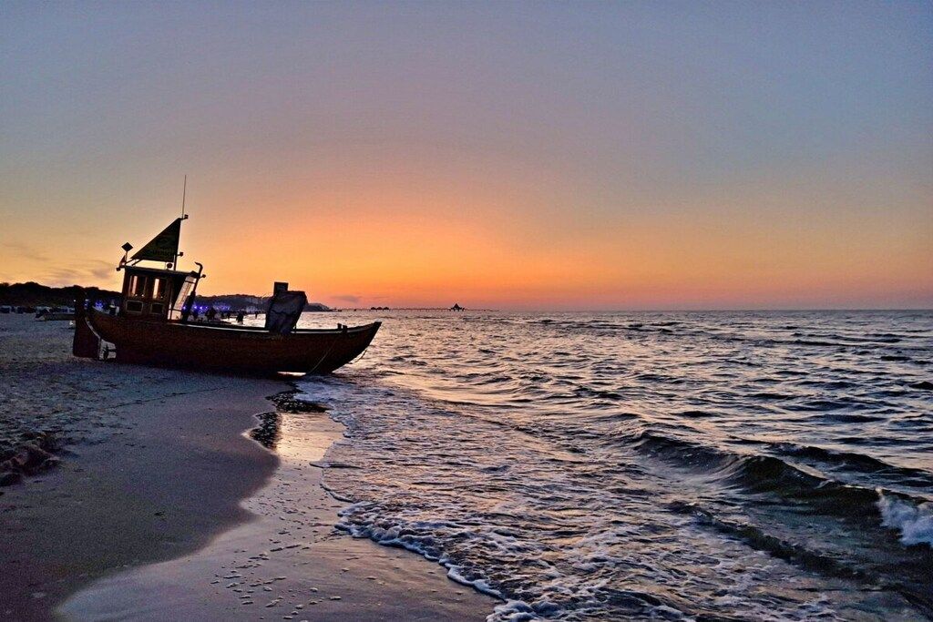 Un bote en la playa al atardecer.