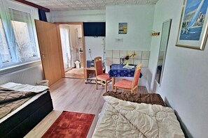 A compact room with a bed, a small table, and a chair. - Holiday apartment Seahorse (Ahlbeck (Seebad))