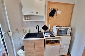 A compact kitchen with a sink, microwave, and cabinets. - Holiday apartment Seahorse (Ahlbeck (Seebad))