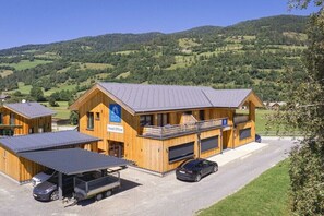 A wooden building with a sign for 'ALPS Resort Head Office' and a car parked in front. - Apartment with 1 bedroom (St. Georgen am Kreischberg)