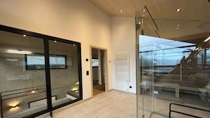 Um interior moderno com divisórias de vidro, uma escadaria e piso revestido.