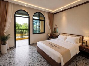 Una habitación de hotel con cama, mesita de noche, planta en maceta y vistas a un balcón.