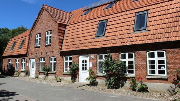 A row of brick buildings with multiple windows and a sloped roof. - Holiday apartment with 1 bedroom (Hasselberg)