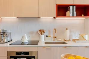 A modern kitchen with a built-in oven, a sink, and a countertop with various items. - Unique Terrace in Midtown Pool (Miami)