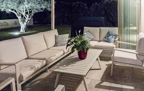 Ein Außenbereich mit einer Couch, einem Tisch und Stühlen.