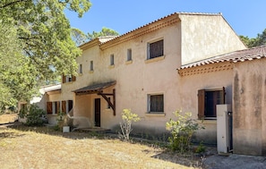 A two-story building with a tiled roof, a wooden porch, and a small garden area. - Cozy home in Besse sur Issole (Besse sur Issole)
