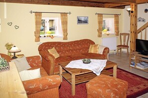 A cozy living room with a sofa, armchairs, a coffee table, and a television. - Nahnsen Farm, holiday under a thatched roof (Leck \/ Klintum)