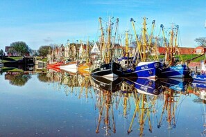 Ein Yachthafen mit vertäuten Booten, ruhigem Wasser und blauem Himmel.